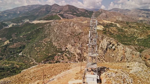 Communication tower overlooking a mountainous landscape in bright daylight Stock Footage 287041574