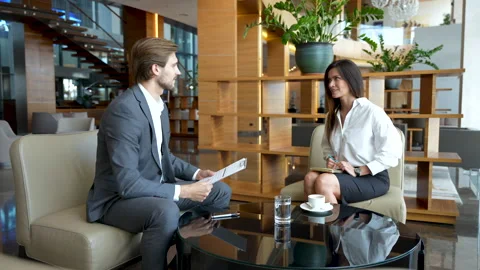 Communication of two business colleagues during break in modern office lobby Stock Footage 224501149