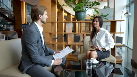 Communication of two business colleagues during break in modern office lobby Stock Footage 224501671