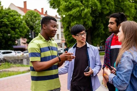 Communication without borders between cheerful multiethnic students Foto stock
