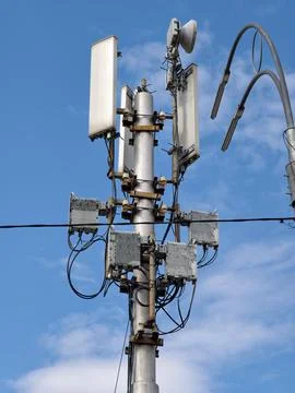 A communications antenna mounted on a low pole, with a streetlight beside i.. Stock Photos
