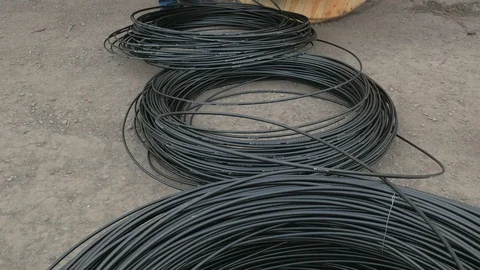 A communications engineer spins an optical cable from a large wooden cable drum. Stock Footage 126939276