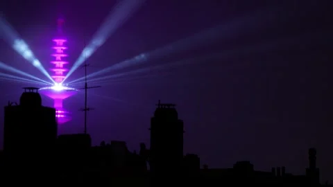 Communications Tower Glowing with Purple Laser Lights at Night in the City 库存影片 331104351