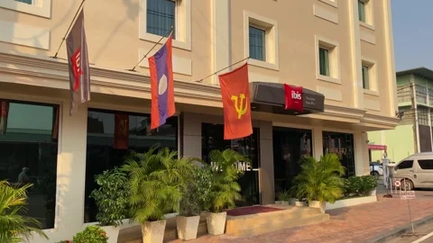 Communism symbol flag is seen in front of Ibis hotel, Vientiane, Laos 4K Stock Footage 273278341