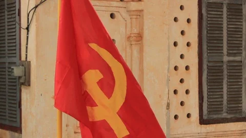 Communist flag hanging from a deteriorating communist style home in Laos Stock Footage 100798609