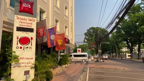 Communist flag is seen in front of a Ibis Hotel in Vientiane, Laos 4K Stock Footage 273278349