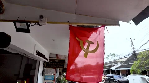 Communist red flag with hammer and sickle symbol hanging from a building in Laos Stock Footage 325326682