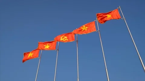 Communist Vietnamese Flags in a Row Against Clear Blue Sky, Saigon, Vietnam Stock-Footage 123080099