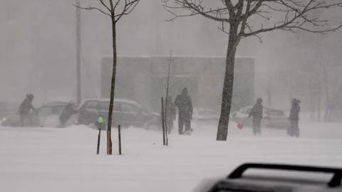 Community collaboration helps dislodge stranded automobile in winter storm Stock Footage 328089180