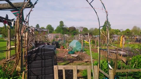 Community garden plot metal archway entrance greenhouse approaching low angle Vídeos de archivo 334823159