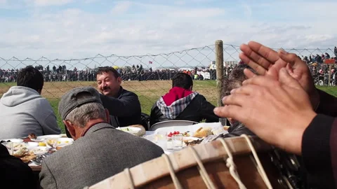 Community gathering around table with food and music outdoors, Canakkale Video stock 327552830