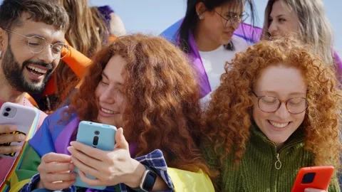 A community of LGBT people sitting using and looking at their mobile phones Stock Footage 268299238