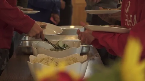 COMMUNITY MEAL MANY HANDS SERVING FOOD Stock Footage 102401397