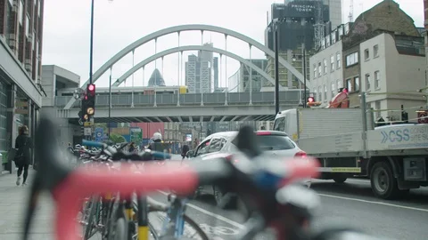 Communter train crosses bridge above busy traffic on an urban street in London. Stock Footage 128818735