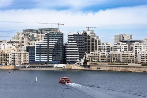 Commuter ferry navigating the harbor with high-rise residential buildings i.. Stock Photos