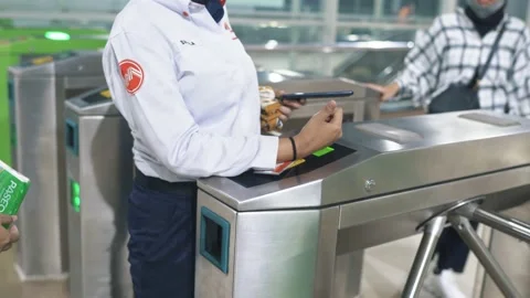 Commuter line passengers are assisted by officers to tapping their card Stock Footage 221394584