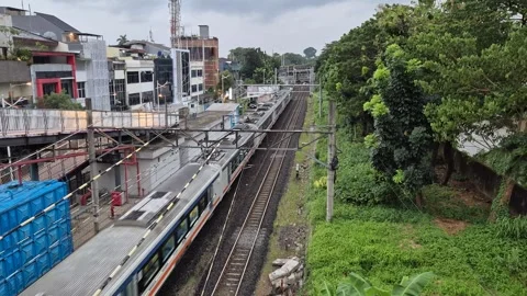 Commuter line train approaching a station in Jakarta Видео 331325139