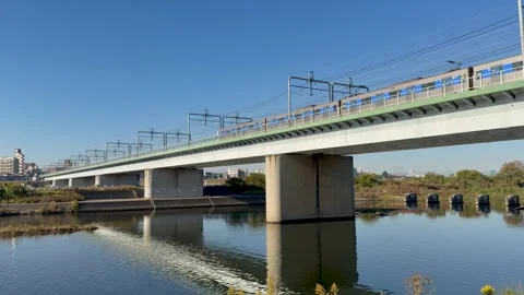 Commuter Train Crossing River Bridge in Tokyo, Japan Stock Footage 321514535