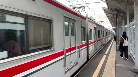 A commuter train drives through a train station in Jakarta, Indonesia Vídeo Stock 301080866