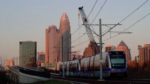 Commuter train on overpass and crane near downtown Charlotte North Carolina Stock Footage 233626973