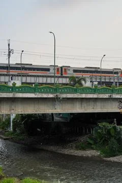 A commuter train passing on an elevated railway bridge. Stock Photos
