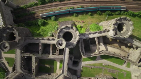 Commuter train passing medieval castle ruins aerial view Stock Footage 336756880