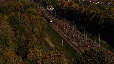 The commuter train is passing through the trees in the evening. Stock Footage 120086163
