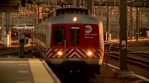 Commuter train pulls away from camera magic hour electric grid Stock Footage 45869045