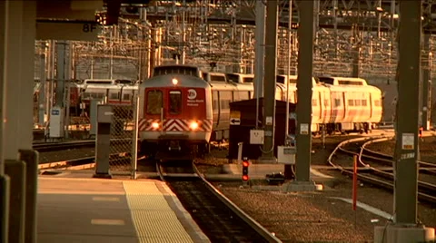 Commuter train pulls into station goes by camera magic hour electric grid 库存影片 45867194