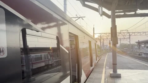 Commuter Train Stopped at Railway Platform During Bright Sunset Stock Footage 339327497