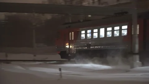 Commuter train traffic at night, in the snowfall Stock Footage 100242015