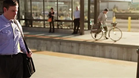 A commuter walks on a train platform and stops to look at the setting sun Stock Footage 45174893