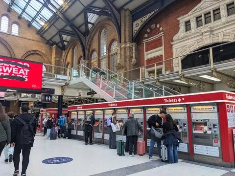 Commuters and tourists queue at ticket machines inside Londons Victorian Stock Photos