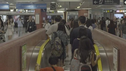 Commuters climbing up the escalator at crowded Central railway station in China Stock Footage 73699036