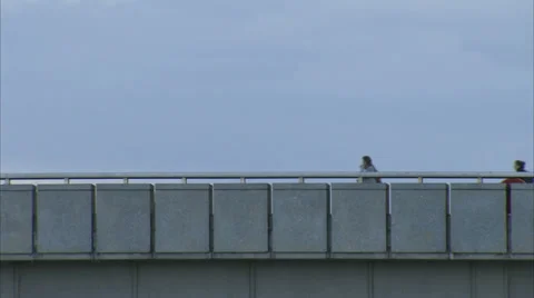 COMMUTERS CROSSING BRIDGE IN EVENING Stock Footage 38285903