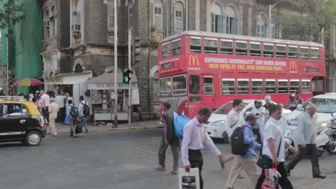 Commuters crossing a street while vehicles are halted on a city traffic signal Stock Footage 171707672