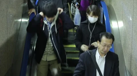 COMMUTERS DESCENDING ESCALATOR AT TRAIN STATION DURING RUSH HOURS IN TOKYO JAPAN Stock Footage