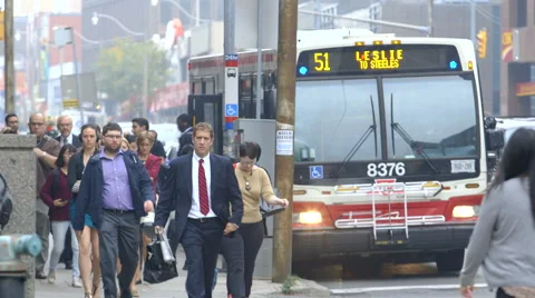 Commuters get off bus and walk down street Stock Footage 44265738