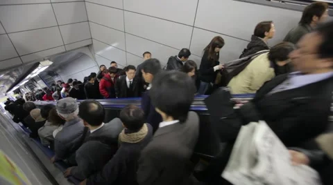 COMMUTERS GOING UP &amp; DOWN ESCALATOR AT TRAIN STATION DURING RUSH HOURS IN TOKYO Video stock 59922007