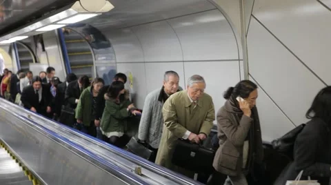 COMMUTERS GOING UP ESCALATOR AT BUSY TRAIN STATION DURING RUSH HOURS IN TOKYO Video stock 59922016