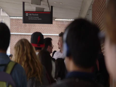 Commuters lined up, waiting for bus on platform Stock Footage 44265608