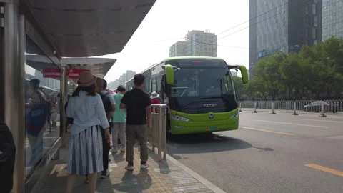 Commuters with masks queueing at Dongzhimen bus stop, Beijing, China Stock Footage 157343191