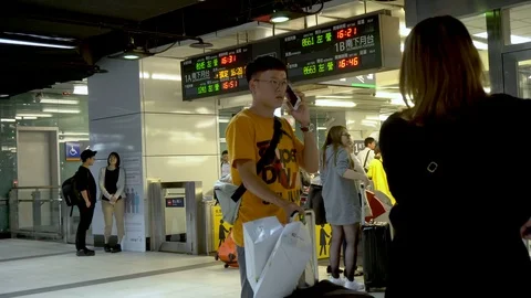 Commuters at Modern Busy Train Station With Ticket Gates and Departure Timetable Stock Footage 106494556