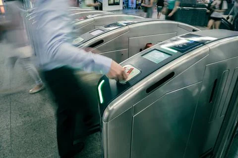 Commuters or passengers going through turnstile in subway Stock Photos