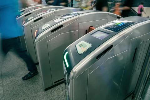 Commuters or passengers going through turnstile in subway Stock Photos