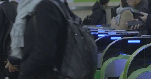 Commuters pass by automatic gate in Japanese station - wider shot - Stock Footage 84644231