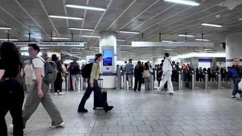 Commuters pass through ticket barriers at busy King's Cross station in London Stock Footage 334328042