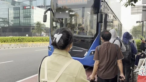 Commuters Queue to Board a City Bus in Jakarta During Rush Hour Stock Footage 340237526