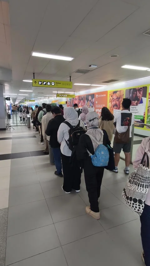Commuters Queuing to Tap Smart Cards at Jakarta MRT Station Exit Gates Stock Footage 338316738