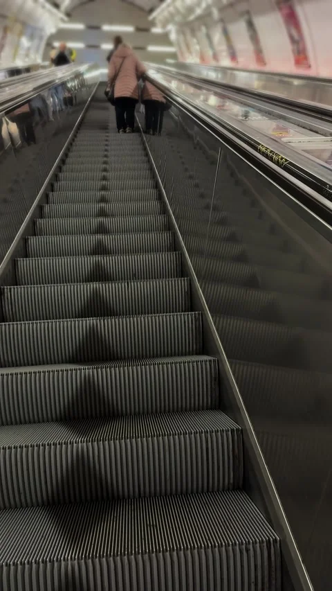 Commuters ride a steep escalator inside the Prague Metro underground network. Stock Footage 342342225